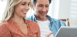 couple looking at tablet smiling.